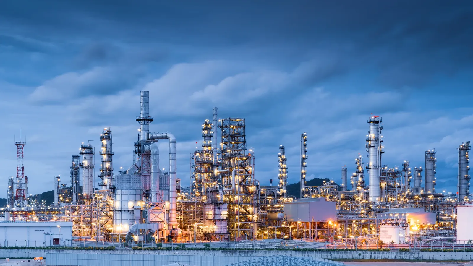 Oil refinery plant lit at dusk
